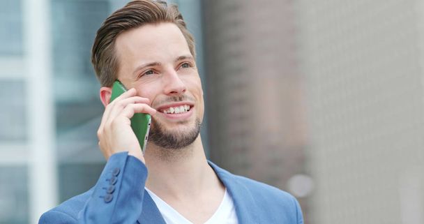 Jovem empresário conversa com celular ao ar livre
 - Foto, Imagem