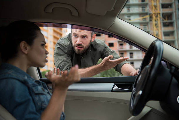 hombre enojado haciendo un gesto al conductor a través de la ventana del coche
 - Foto, Imagen