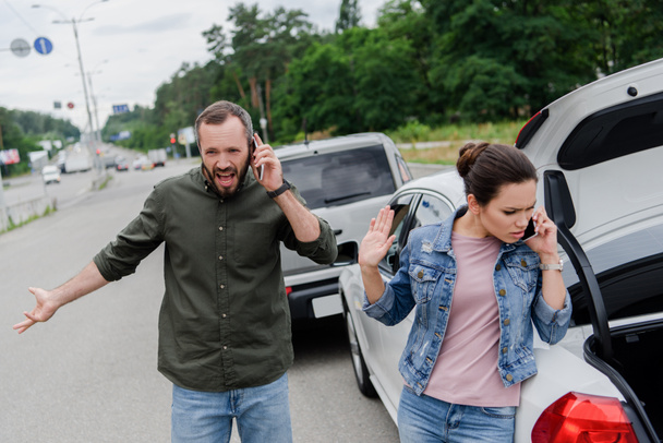 geïrriteerde bestuurders praten door smartphones op weg na auto-ongeluk - Foto, afbeelding