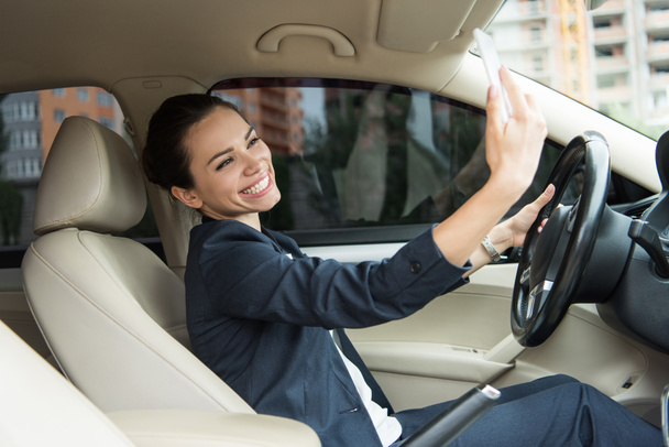 motorista sorridente atraente levando selfie com smartphone no carro
 - Foto, Imagem