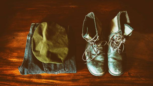 Old Military uniform placed on the wooden floor, vintage color tone. - Photo, image