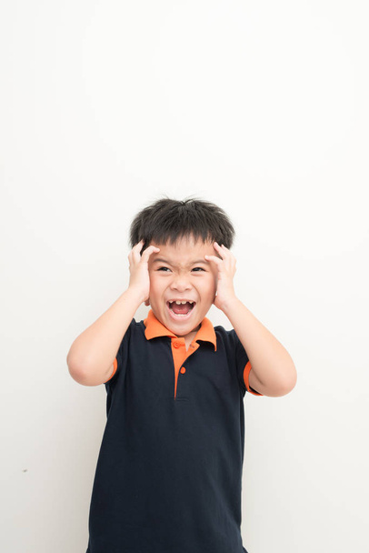 Χαριτωμένο μικρό αγόρι που καλύπτουν τα αυτιά με τα χέρια να στέκεται πάνω σε λευκό φόντο - Φωτογραφία, εικόνα
