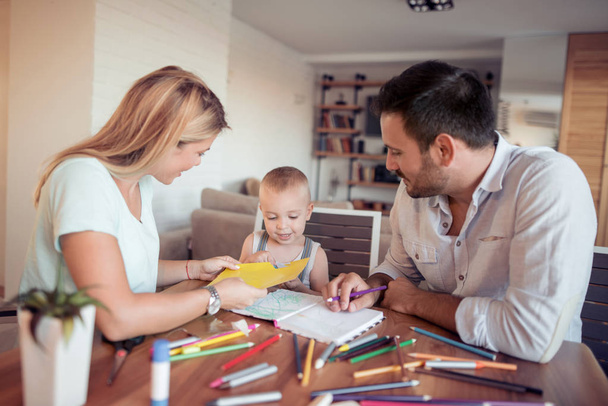 Buntstifte zeichnen Familie, Vater und Mutter sieht aus, wie Sohn zeichnet. - Foto, Bild
