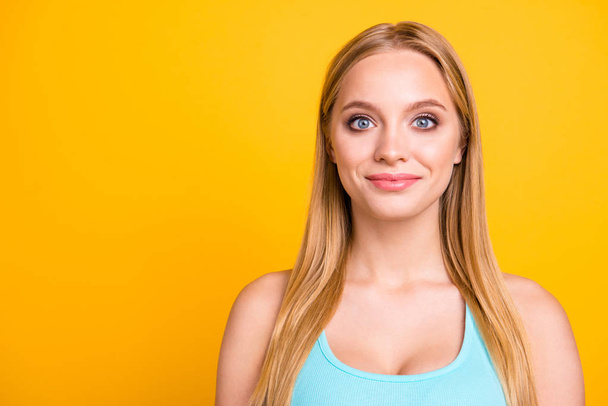 Close up image of young cute and beautiful girl with blond hair and lovely smile. Female model looking at camera, isolated on yellow background with copy space for text - Fotó, kép