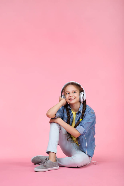 Young girl with headphones on pink background - Φωτογραφία, εικόνα