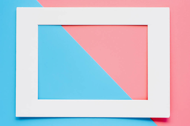 White paper frame on pink and blue pastel color background - Foto, afbeelding
