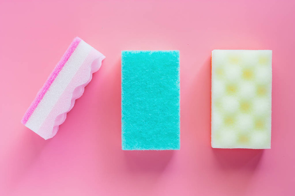 Esponjas exfoliantes sobre fondo rosa para la limpieza de la cocina
 - Foto, imagen