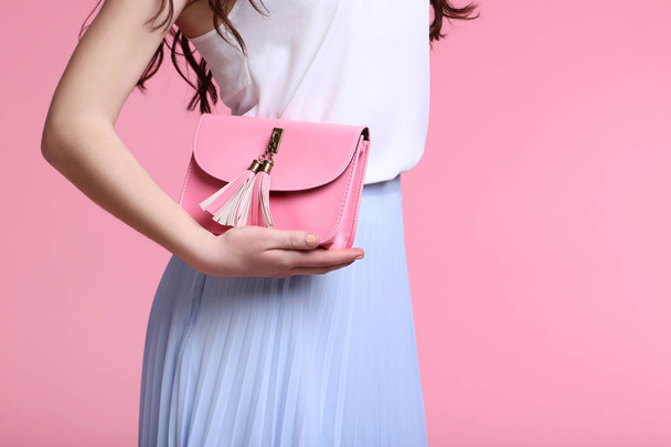 Young woman with handbag on pink background - Photo, image