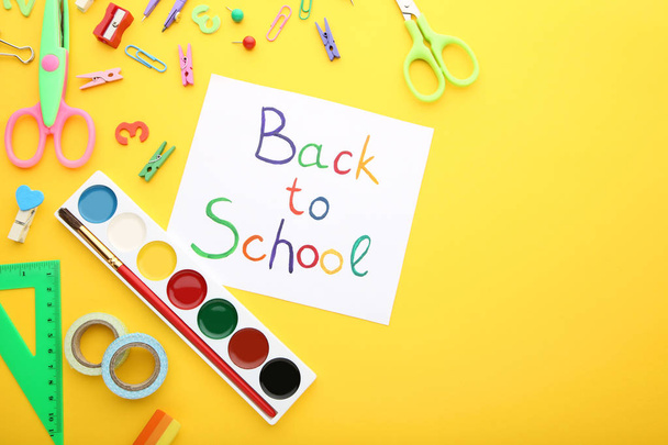 Inscriptions Back To School with school supplies on yellow background - Fotoğraf, Görsel