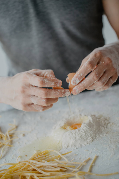 Closeup of process of making cooking homemade pasta. Chef make fresh italian traditional pasta. Breaking egg - Zdjęcie, obraz