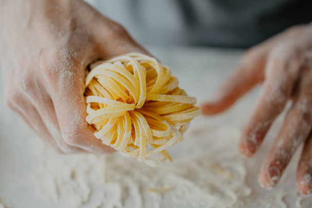 自家製パスタ料理を作る過程のクローズ アップ。シェフは、イタリアの伝統的なパスタを作る  - 写真・画像