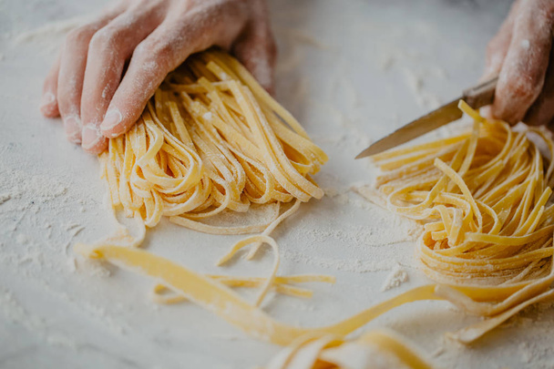 Closeup of process of making cooking homemade pasta. Chef make fresh italian traditional pasta  - Foto, afbeelding