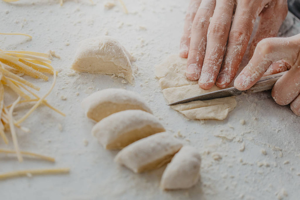 Process of cutting dough making dish cooking homemade dough. Chef makes fresh dough  - Foto, Imagen