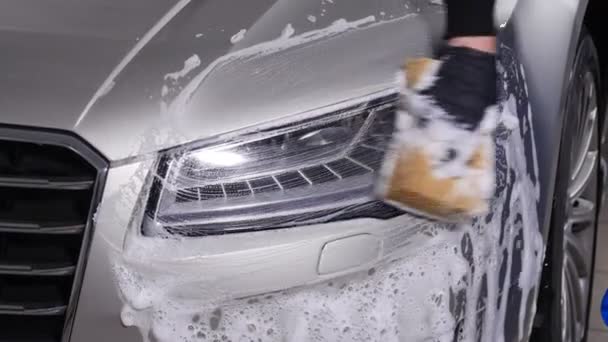 Ένας άνθρωπος πλένει προβολείς των αυτοκινήτων. Έννοια της μη αυτόματης πλύσιμο αυτοκινήτων - Πλάνα, βίντεο