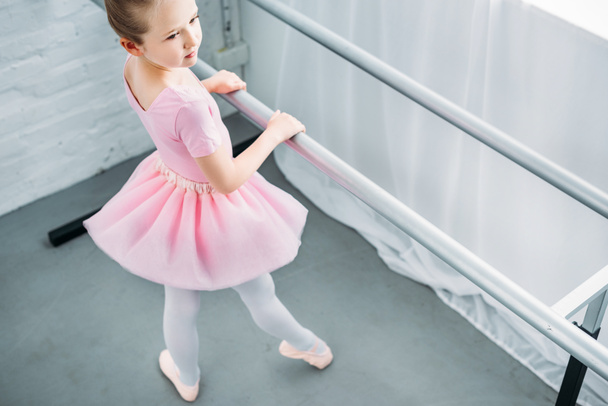 high angle view of graceful little ballerina exercising in ballet school - Photo, Image