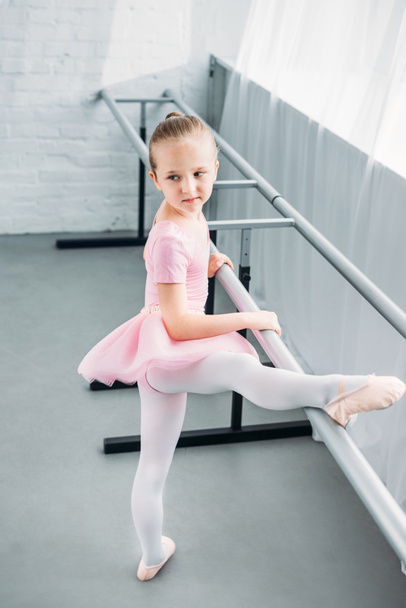 высокий угол обзора ребенка в розовой пачке упражнения в балетной школе
 - Фото, изображение