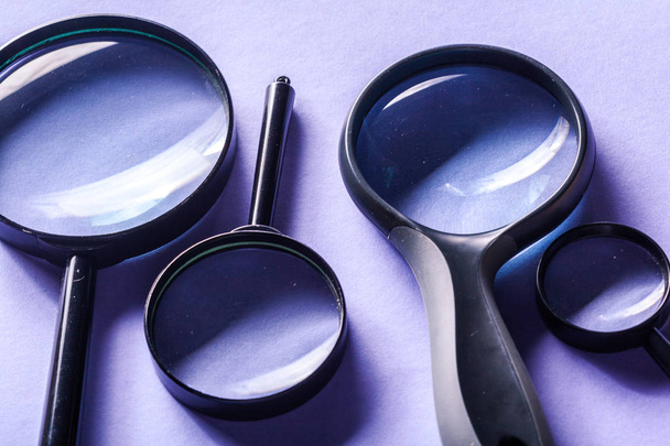 Close view of magnifier glasses on purple background - 写真・画像