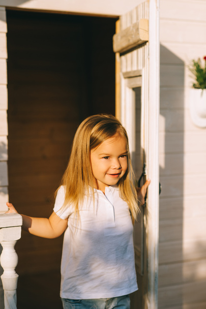 portrait of little kid standing on porch on summer day - 写真・画像