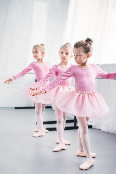 прелестные маленькие балерины, практикующиеся вместе в балетной студии
 - Фото, изображение