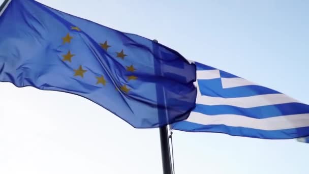 Ελληνική και κοινοτική σημαία κυματίζει μαζί ενάντια σε ένα εντυπωσιακό γαλάζιο ουρανό. Αργή κίνηση - Πλάνα, βίντεο
