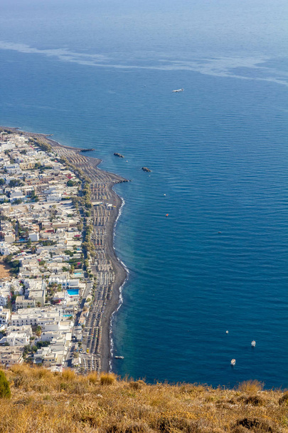 Emelt szintű táj jelenet Santorini. Kamari, Görögország, a fent említett. Csodálatos nappali részleges kilátás a színes város és a strand és a tenger felé, a reggel - Fotó, kép