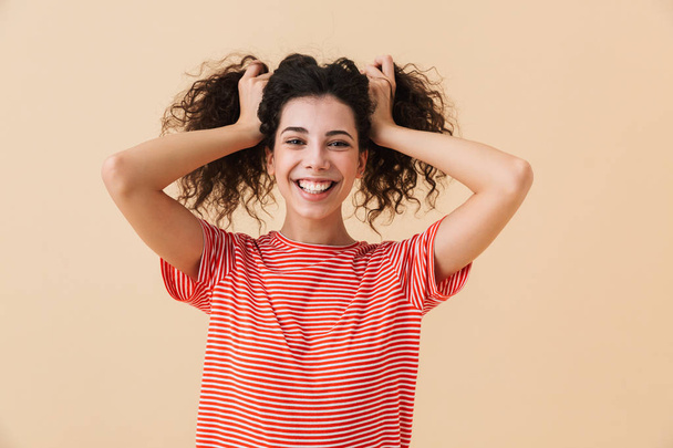 Photo of happy young woman isolated over beige wall background looking camera. - Φωτογραφία, εικόνα