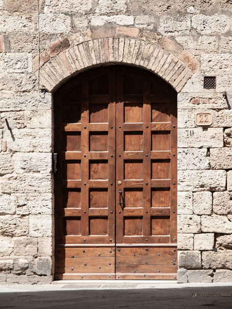 Old brown wooden door in medieval street - Fotoğraf, Görsel