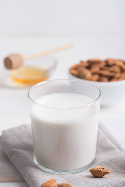 Almond milk and honey on a white wooden table. - 写真・画像