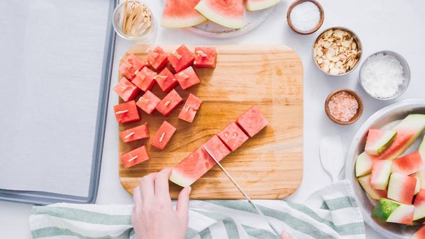 Watermeloen in kubussen voor het voorbereiden van chocolade overdekte watermeloen opsplitsen bijt. - Foto, afbeelding