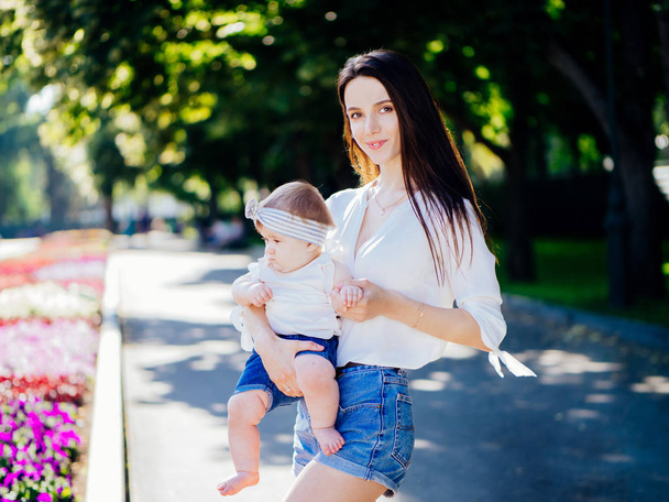 Moeder met meisje van de baby van 8 maanden tijd doorbrengen in een park - Foto, afbeelding
