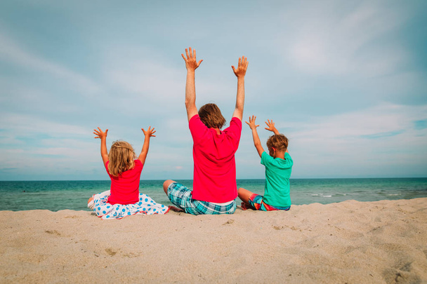 padre con pequeño hijo e hija divirtiéndose en la playa
 - Foto, imagen