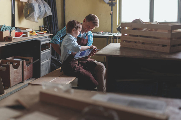Genitore e figlio al lavoro in falegnameria
 - Foto, immagini