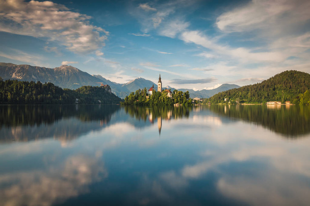 Church on the island on Lake Bled and his reflection in water, Slovenia - Фото, изображение