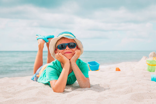 leuke jongen spelen met zand op strand - Foto, afbeelding