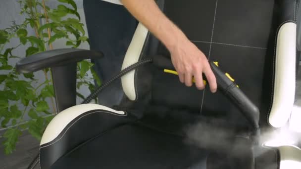Hand reinigt Bürostuhl mit einem Dampfreiniger. Hausreinigungskonzept. - Filmmaterial, Video