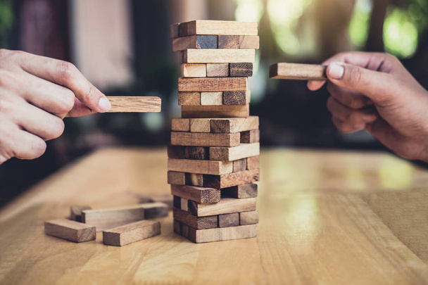 Hands of executive cooperation placing wood block on the tower, Collaborative management, Young intelligent businessman playing the wood game, Alternative risk concept, plan and strategy in business. - Foto, Imagem