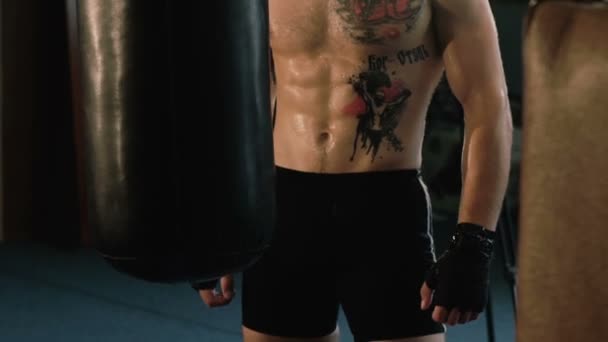 Hairless with pigtail on a head and tattoos, free fighter training punching bag. - Záběry, video