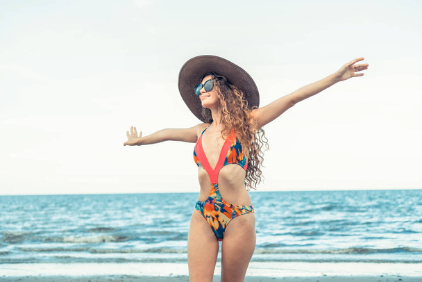 Счастливая молодая женщина в купальнике хорошо проводит лето на пляже в отпуске
. - Фото, изображение