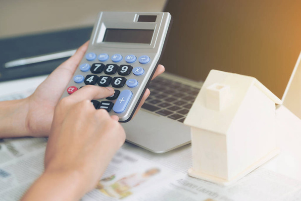 Nő könyvelő vagy banki munkavállaló kalkulátor az irodában kiszámítására használja house hitel hitel bürokrácia. - Fotó, kép