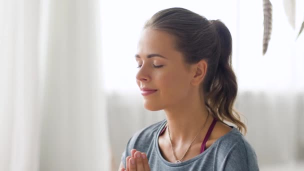 mindfulness, spirituality and healthy lifestyle concept - woman meditating at yoga studio - Filmati, video