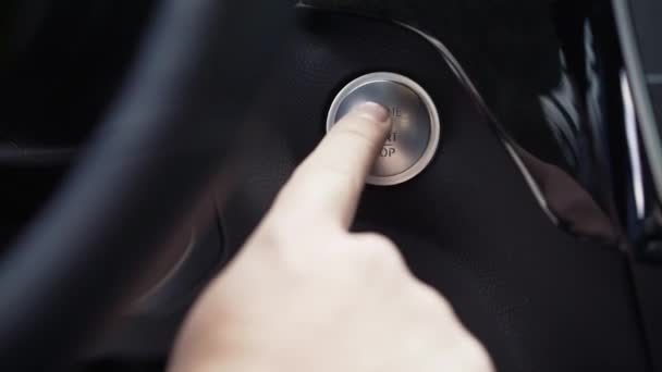 Řidič ruka tlačí tlačítko engine stop start. V UK. Moderní luxusní crossover auto detaily interiéru - Záběry, video