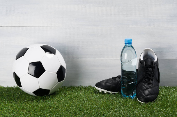 Clean water in a bottle and the concept of football on a green lawn - 写真・画像