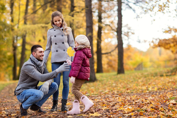 famiglia felice con foglia d'acero al parco autunnale
 - Foto, immagini