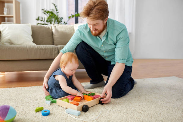 father and baby playing with toy blocks at home - Фото, изображение