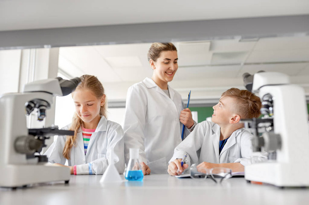 teacher and students studying chemistry at school - Фото, изображение