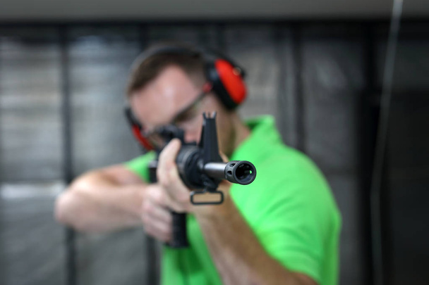 Shooting range. Handsome man trains shooting at the sports shooting range. - Foto, Imagem