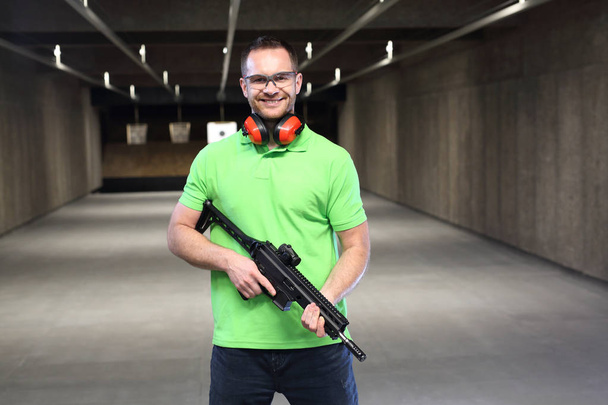 At the shooting range.Handsome man trains shooting at the sports shooting range. - Foto, Imagem