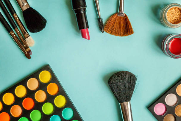 Herramientas para maquillaje y cosméticos diferentes tonos de sombra de ojos sobre fondo azul
 - Foto, imagen