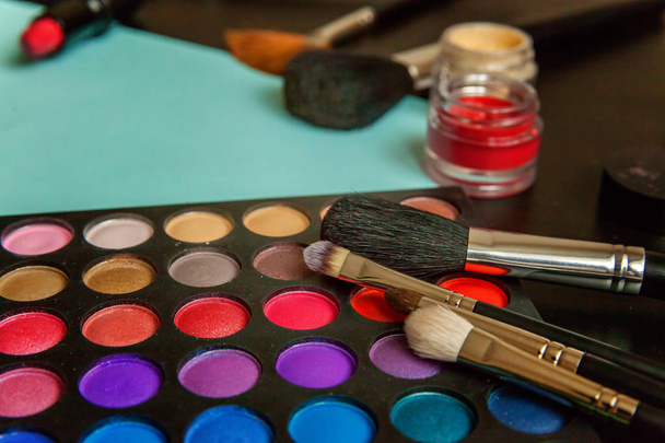 Nástroje pro make-up a kosmetika různé odstíny očních stínů na modrém pozadí - Fotografie, Obrázek