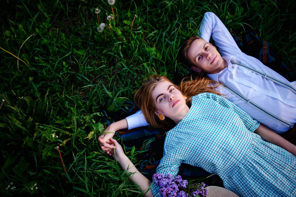 young couple lying on the grass and relax, view from above. - Φωτογραφία, εικόνα